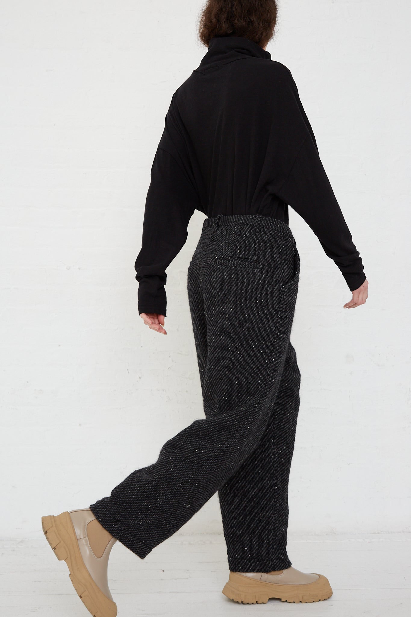 A woman wearing Ichi Antiquités Snow Nep Wool Pant in Black and tan boots. Side view.