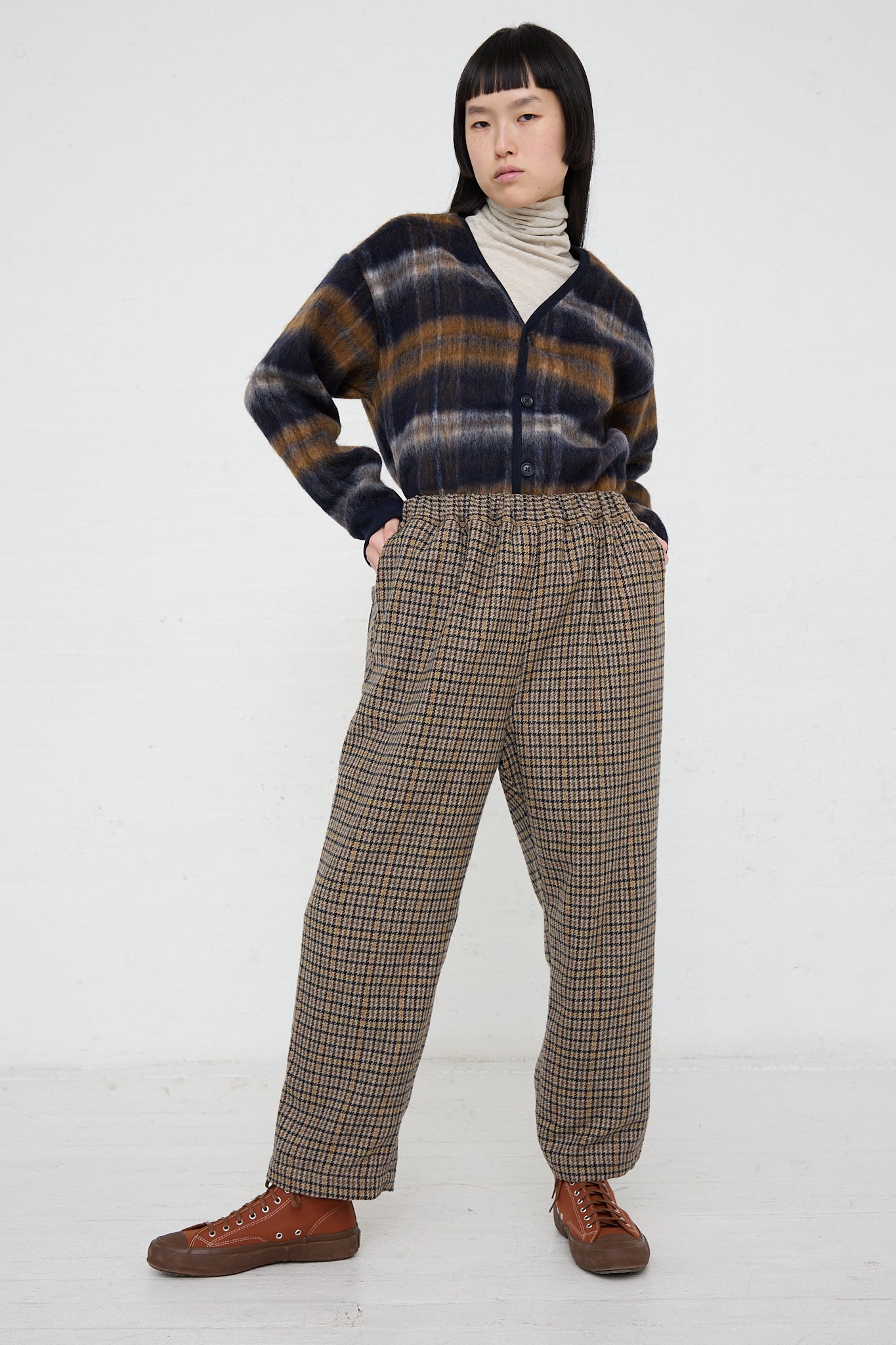 A woman wearing an Ichi mocha check plaid sweater and Ichi relaxed fit pants in Woven Pant in Mocha Check.