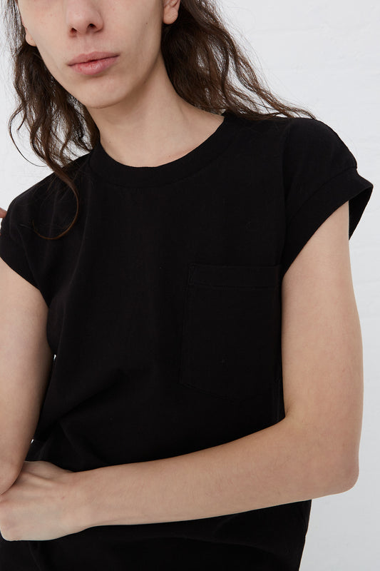 A woman wearing a black Pocket Tank in Black t-shirt by B Sides with a pocket.