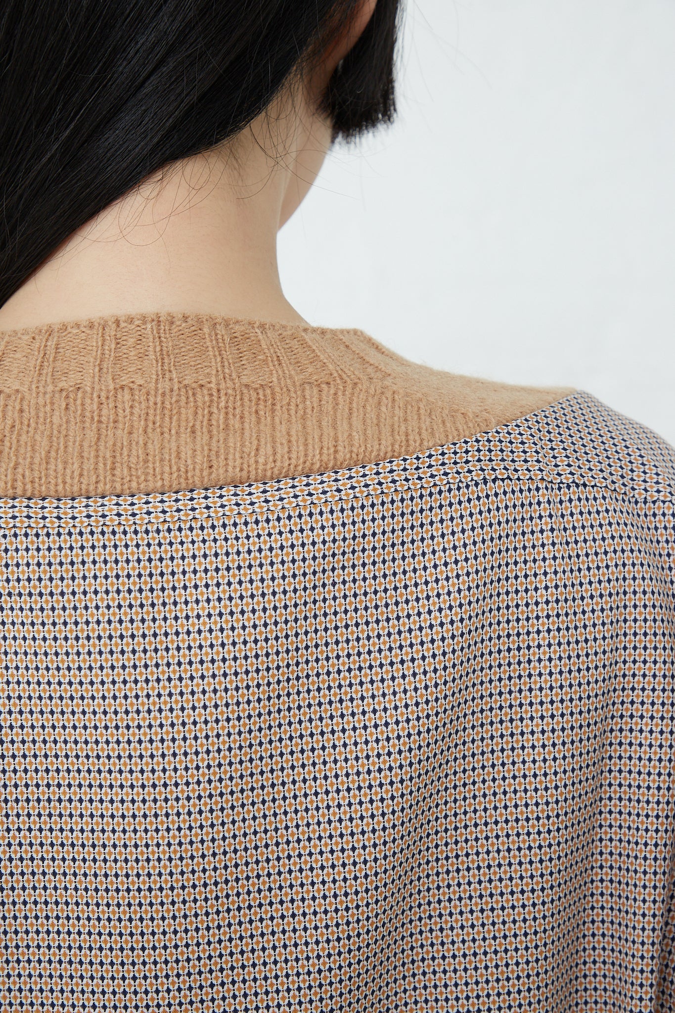 The back view of a woman wearing the Bless No. 68 Front Insert Pullover in Beige Pattern made from Shetland wool.