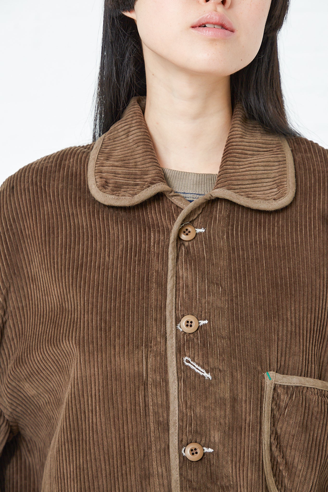 A woman wearing a vintage-inspired Big Wales Corduroy Cunningham Jacket in Grey Volcano by Dr. Collectors with button closure. Up close view.