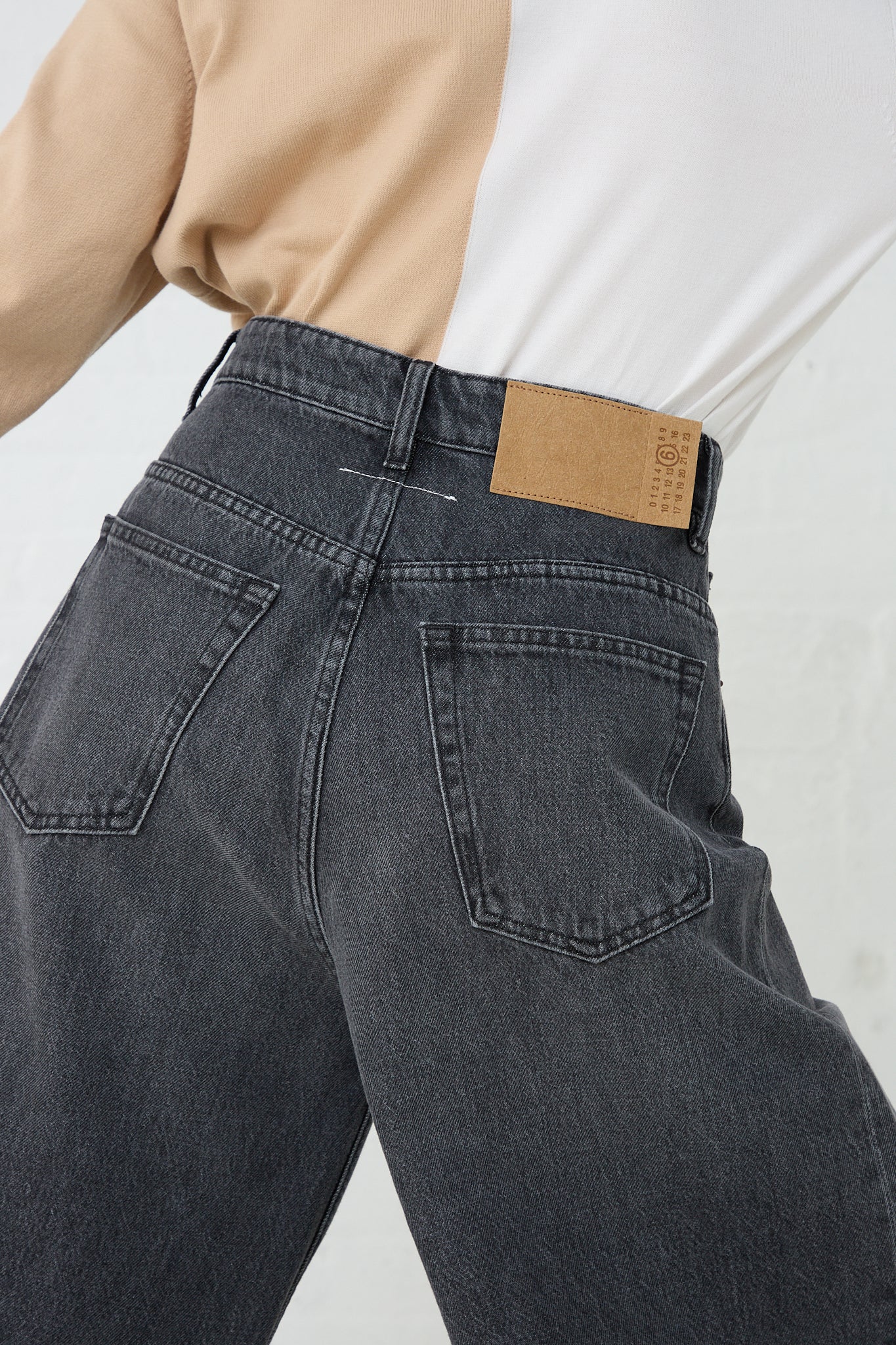The back of a woman's MM6 gray denim jeans with 5 Pockets Pant in Grey. Up close view of back pocket details.