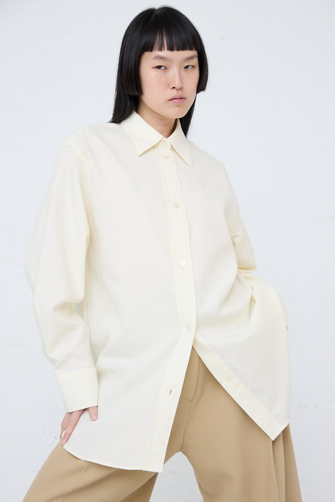 The model is wearing the Santos Overshirt in Parchment by Studio Nicholson.