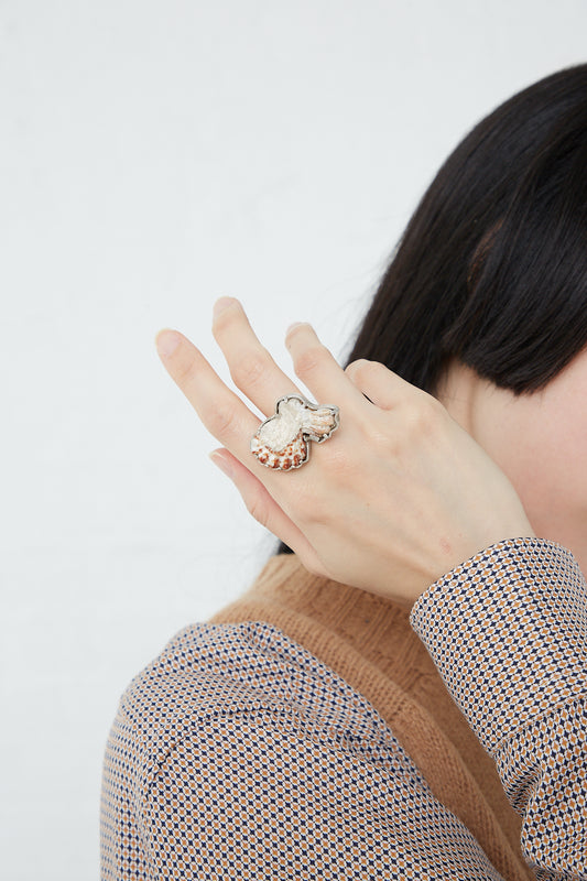 A woman wearing a La Ma r Sterling Silver Shell Ring 003 B, embellished with a found shell.