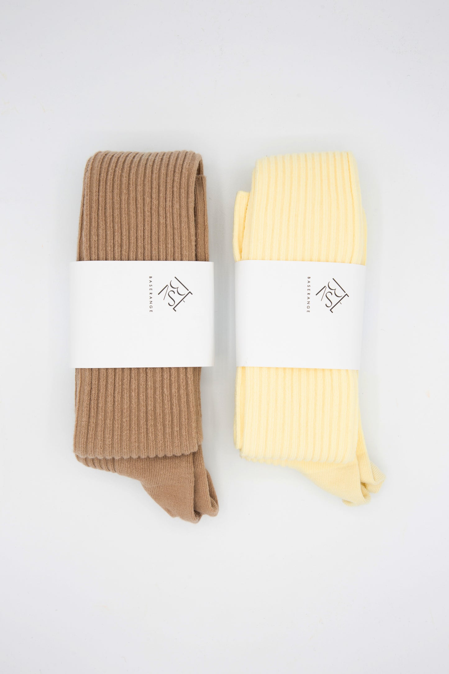 Two pairs of Baserange Overknee Sock in Brandy, sustainably produced, organic cotton blend socks on a white surface.