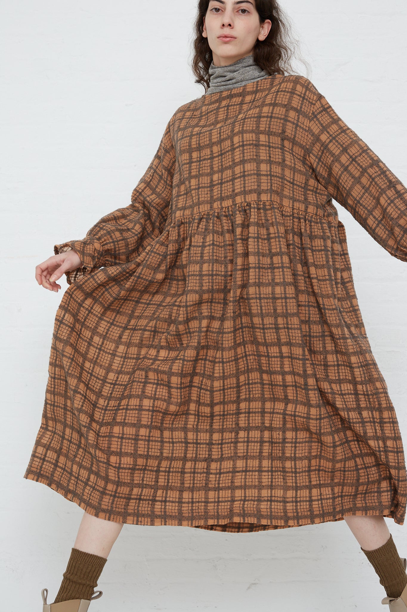 The model is wearing a long sleeve Woven Wool Check Dress in Terracotta by Ichi Antiquités.
