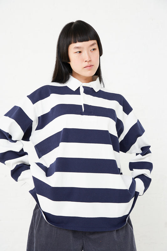 A woman wearing a Toujours Cotton Jersey Rugby Shirt in Off White/Blue Stripe. Available at Oroboro Store.