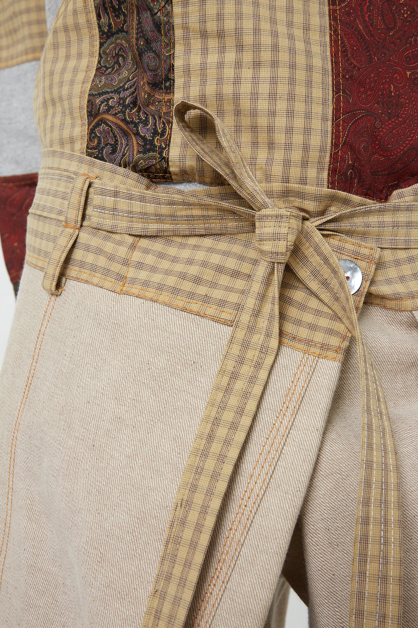 A close up of an oversized SC103 belt with a Check Cotton Jupiter Pant in Tent pattern made of cotton.