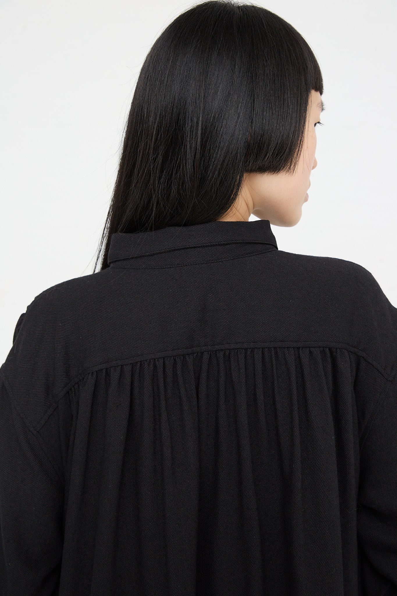The back view of a woman wearing an Ichi Woven Dress in Black made from natural fibers. Up close.