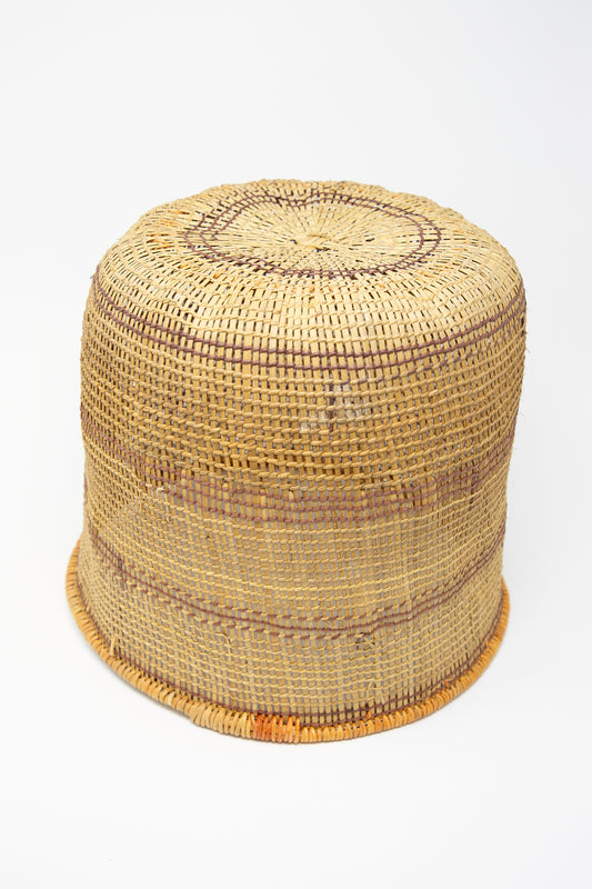 A Plaza Bolivar rattan hat with natural dyes on a white background.