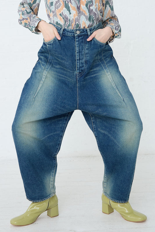 A woman wearing a pair of Mina Perhonen Always New Tapered Pant in Blue made from a cotton linen blend and featuring a 5-pocket design. Front view and up close. Model's hands are in front pockets.