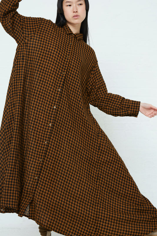 The model is wearing an Ichi Wool Check Dress in Mustard and Black with an oversized fit.