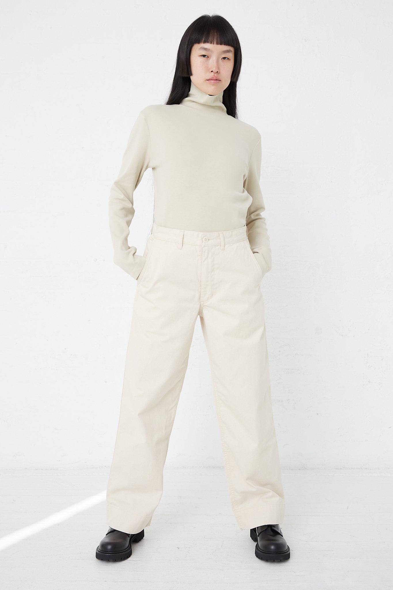 A woman wearing As Ever's 51 Chino in Natural wide leg pants in beige.