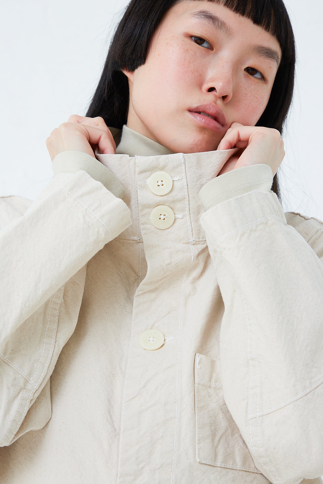 A woman wearing a Jesse Kamm Organic Canvas Deck Jacket in Natural made of organic cotton.
