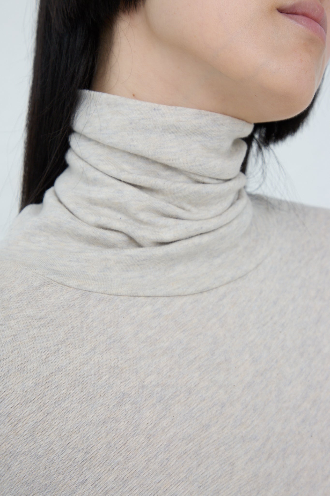 A woman wearing an Ichi relaxed fit, long sleeve Cotton Knit Turtleneck sweater in Oatmeal.