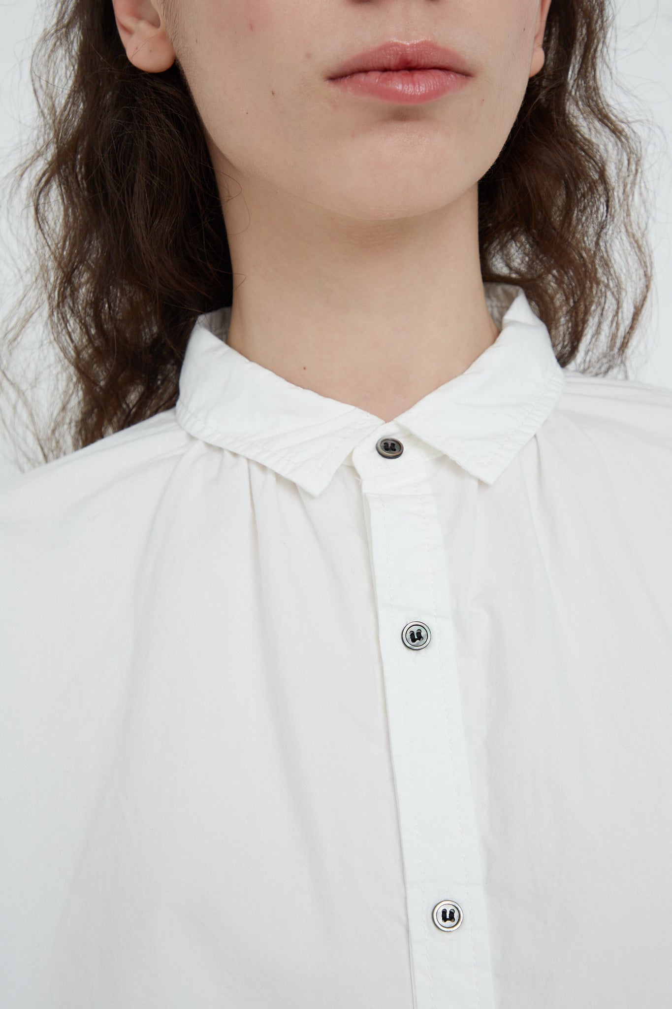 A woman wearing an Ichi Antiquités Woven Cotton Oumisarashi Shirt in White with buttons. Up close view.