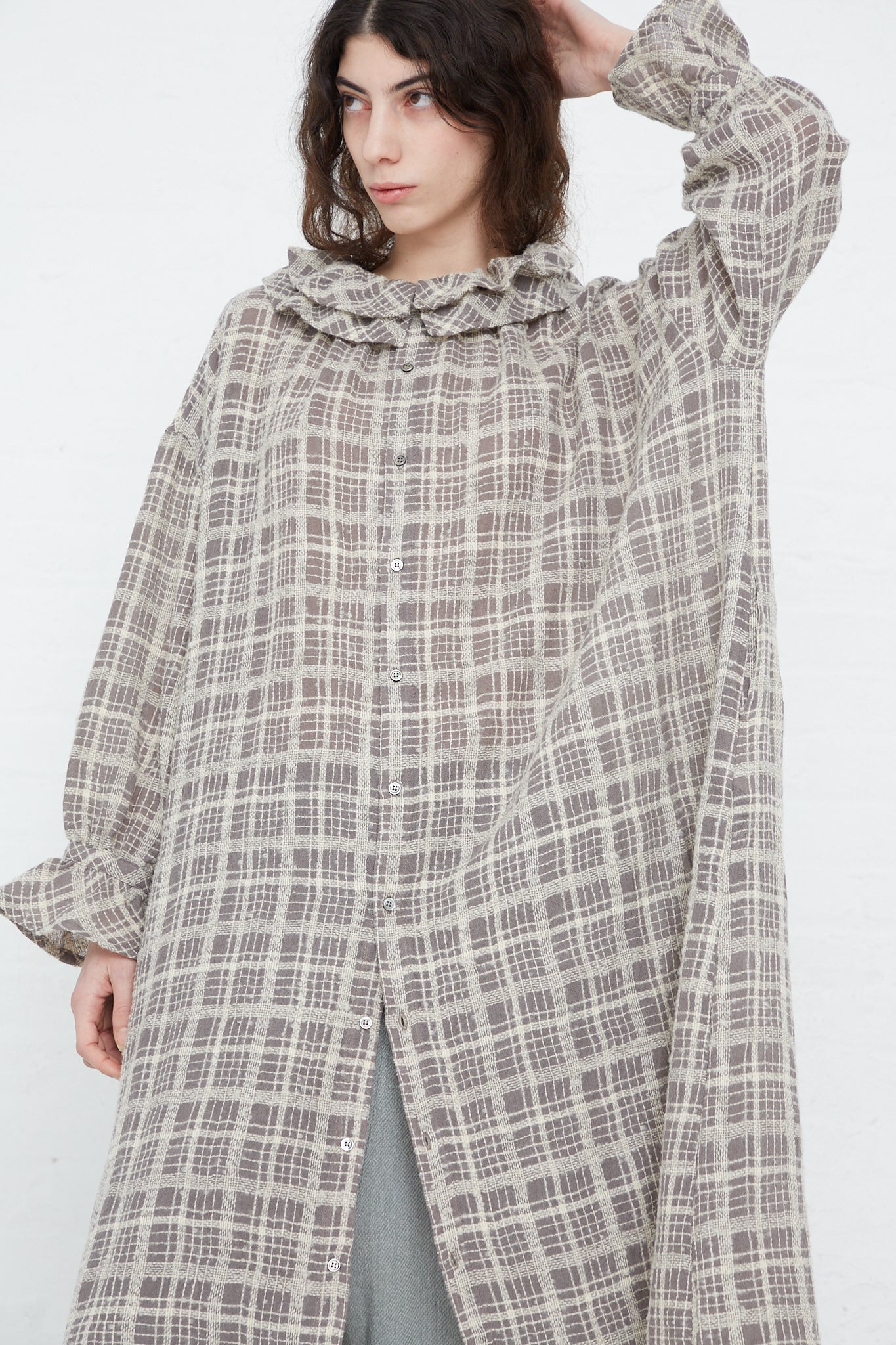 The model is wearing a Wool Check Frill Dress in Mocha by Ichi Antiquités.