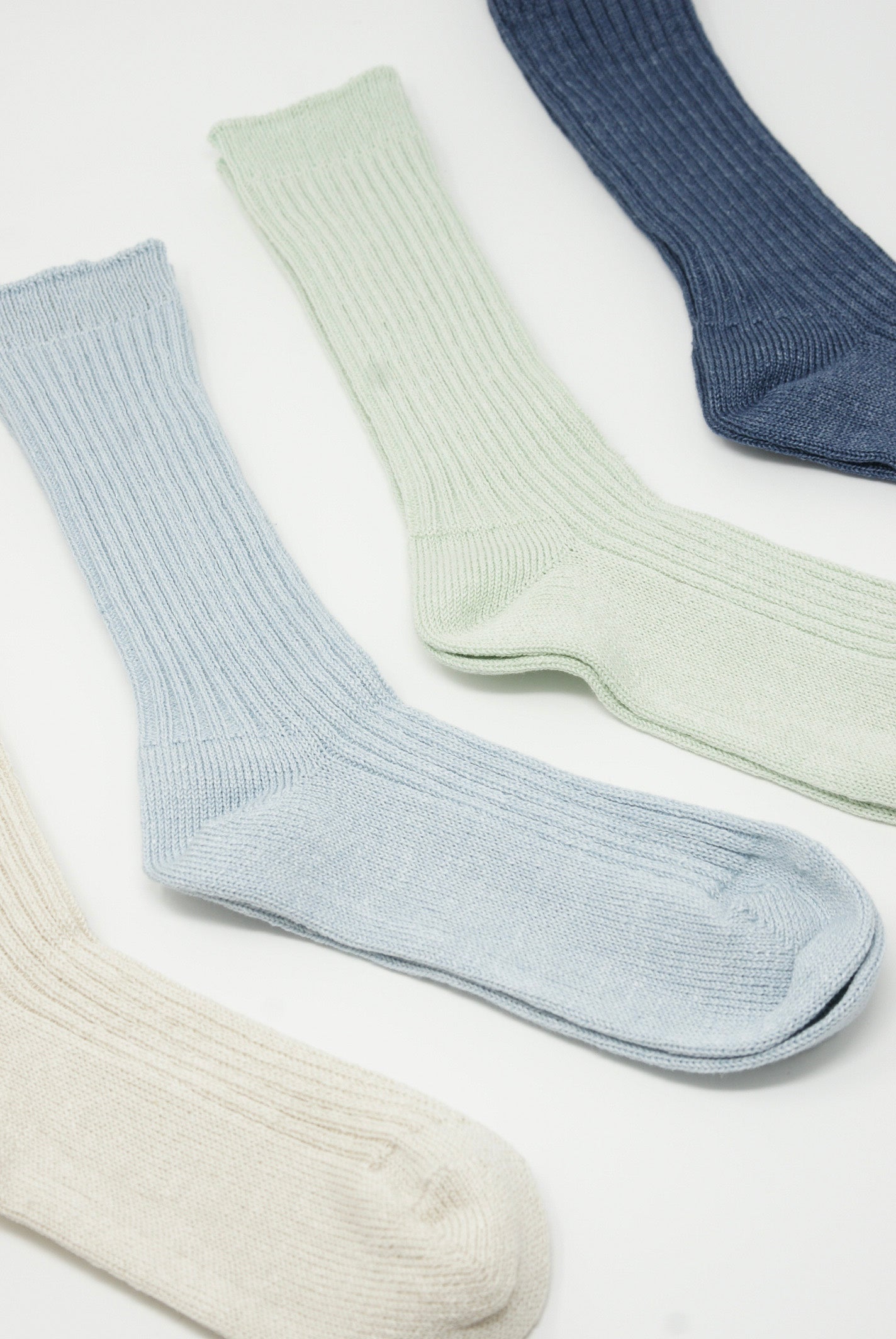 Four pairs of Ichi Antiquités Linen Rib Socks in Blue, made with a linen blend, placed on a white surface.
