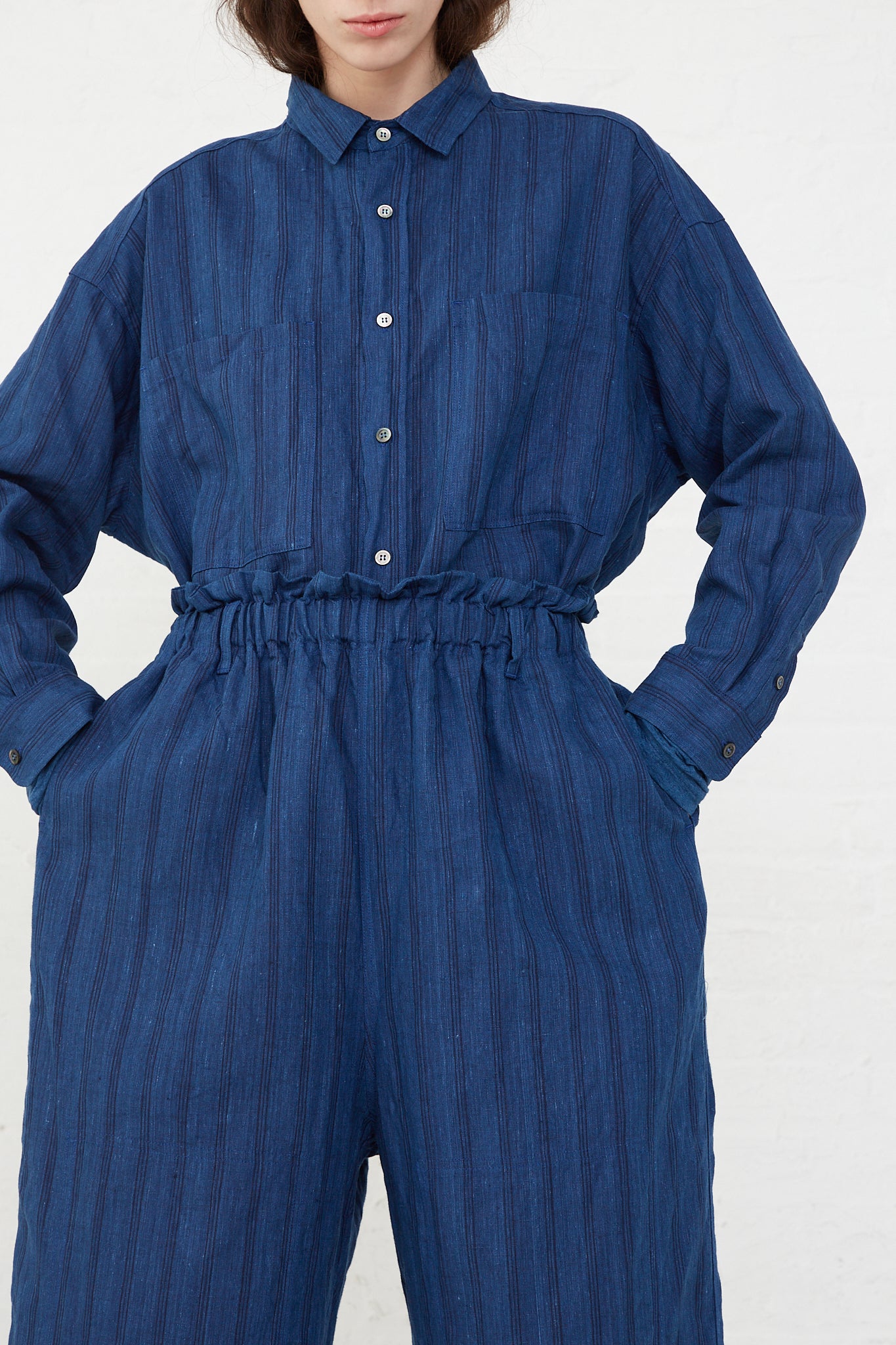 A woman wearing the Ichi Antiquités Woven Linen Pant in Indigo Stripes with an elasticated waist.