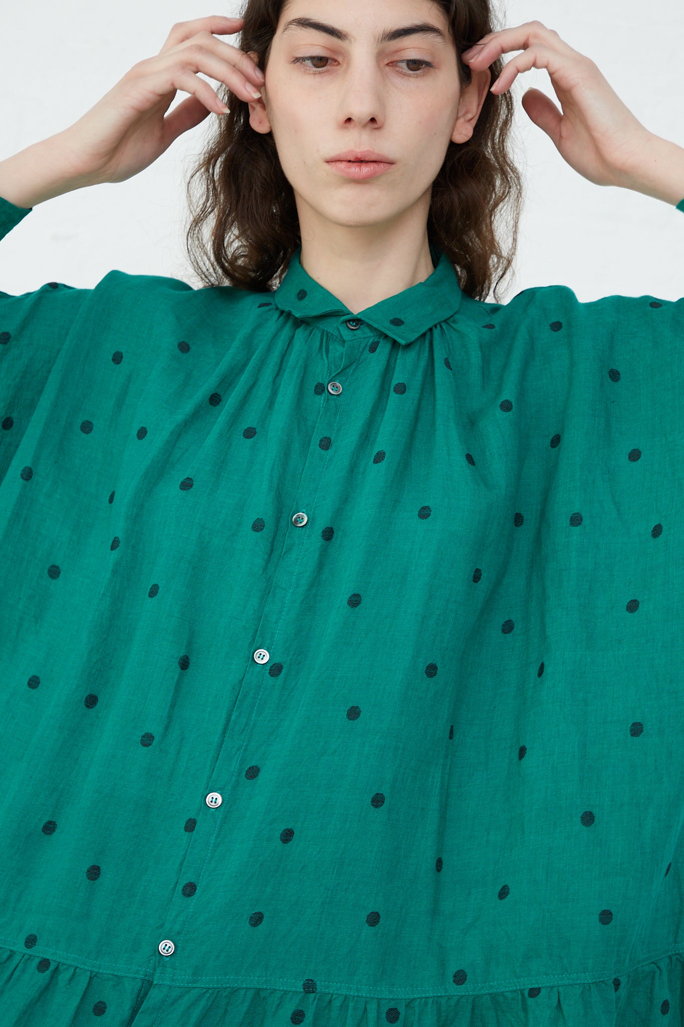The model is wearing a Linen Dot Dress in Green and Black by Ichi Antiquités. Up close view.