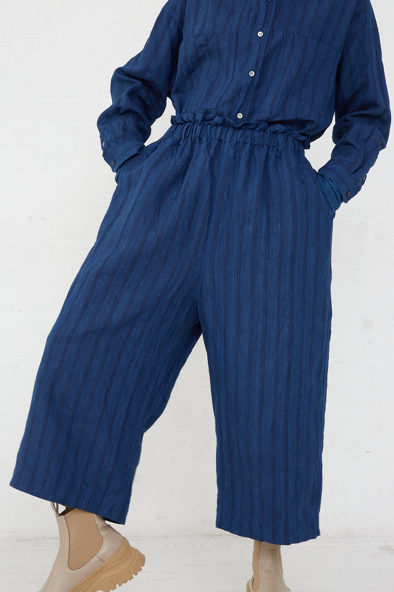 A woman wearing the Ichi Antiquités Woven Linen Pant in Indigo Stripes with an elasticated waist.