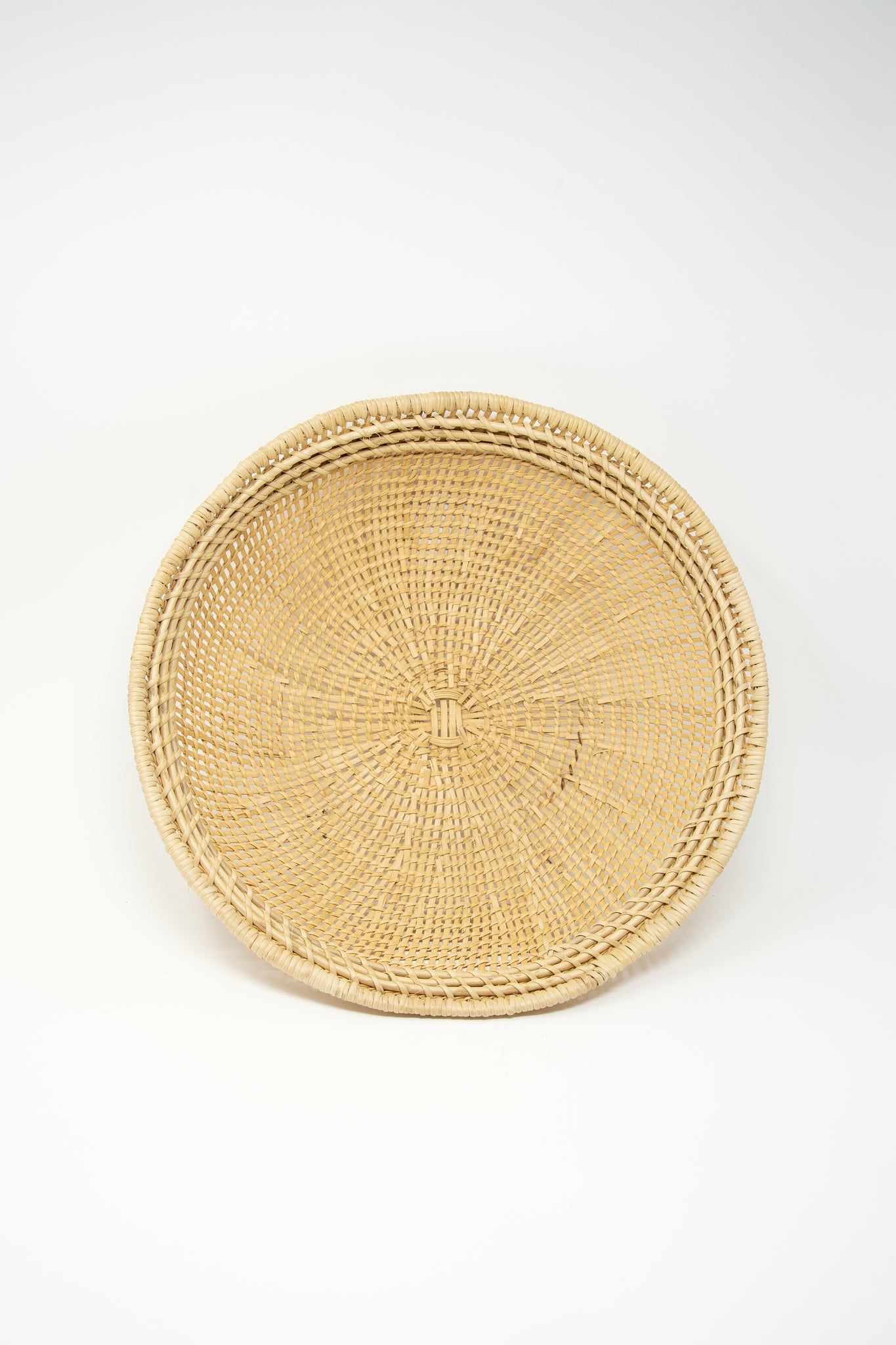 An artisan-crafted Plaza Bolivar rattan basket, showcasing intricate weaving techniques, set on a pristine white background.