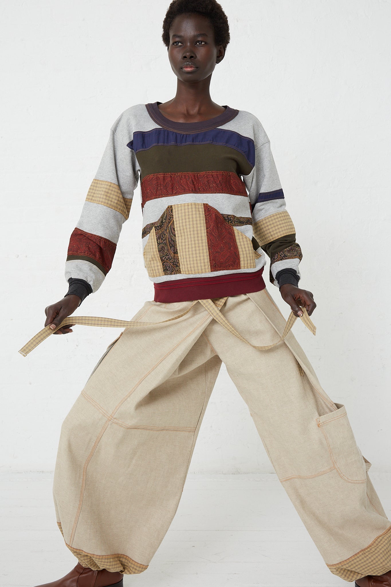 A woman wearing an oversized striped sweater and SC103 Check Cotton Jupiter Pant in Tent.