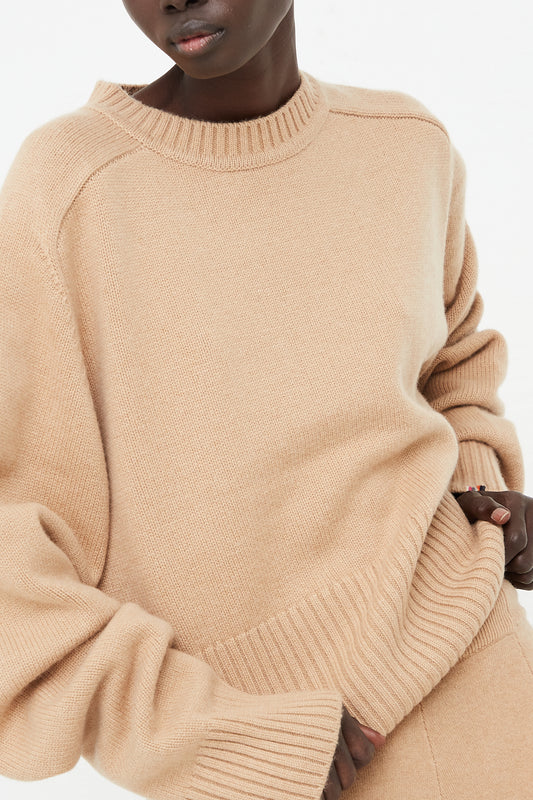 The model is wearing an Extreme Cashmere No. 256 Judith Sweater in Camel - Oroboro Store