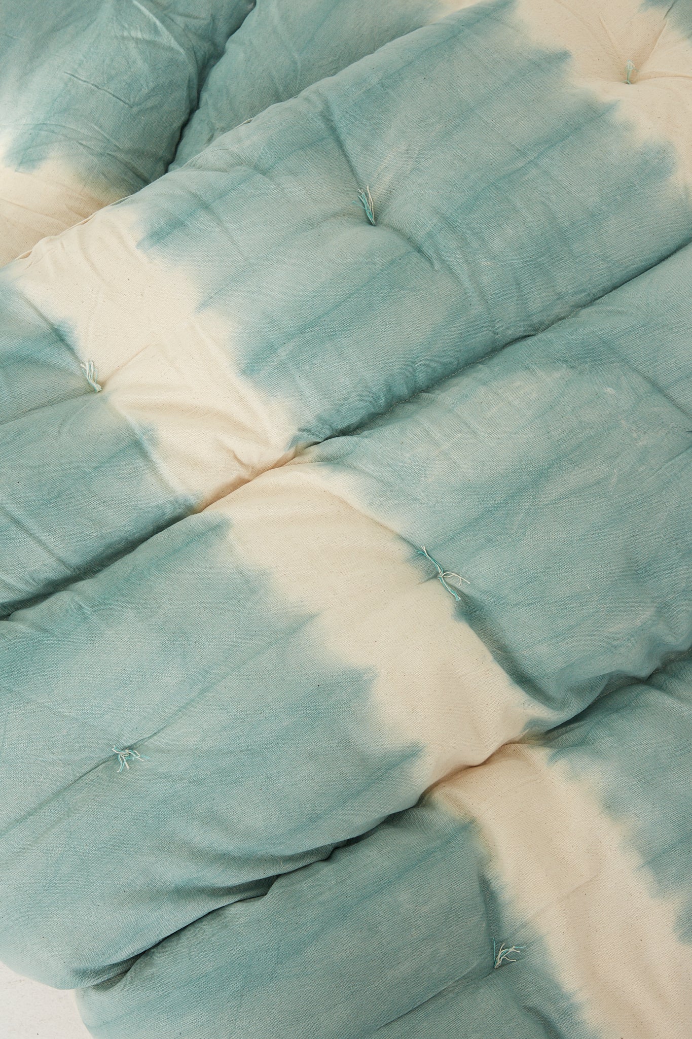 A sustainable cotton Tufted Overlay Mattress in Celadon Green Tie Dye, featuring tufted stitching for added texture, by Tensira.