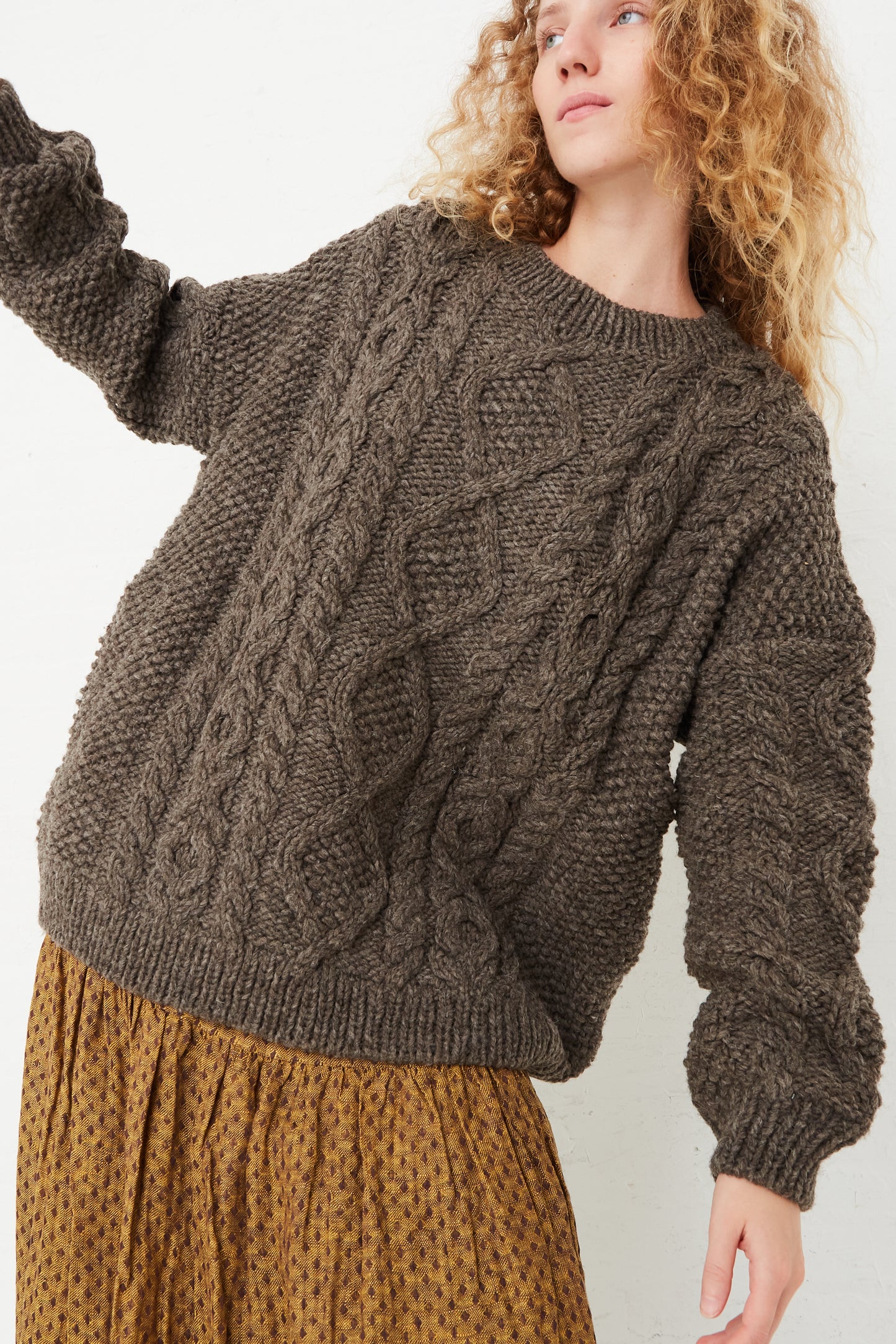 The model is wearing an Ichi Antiquités Wool Hand-Knit Pullover in Mocha.