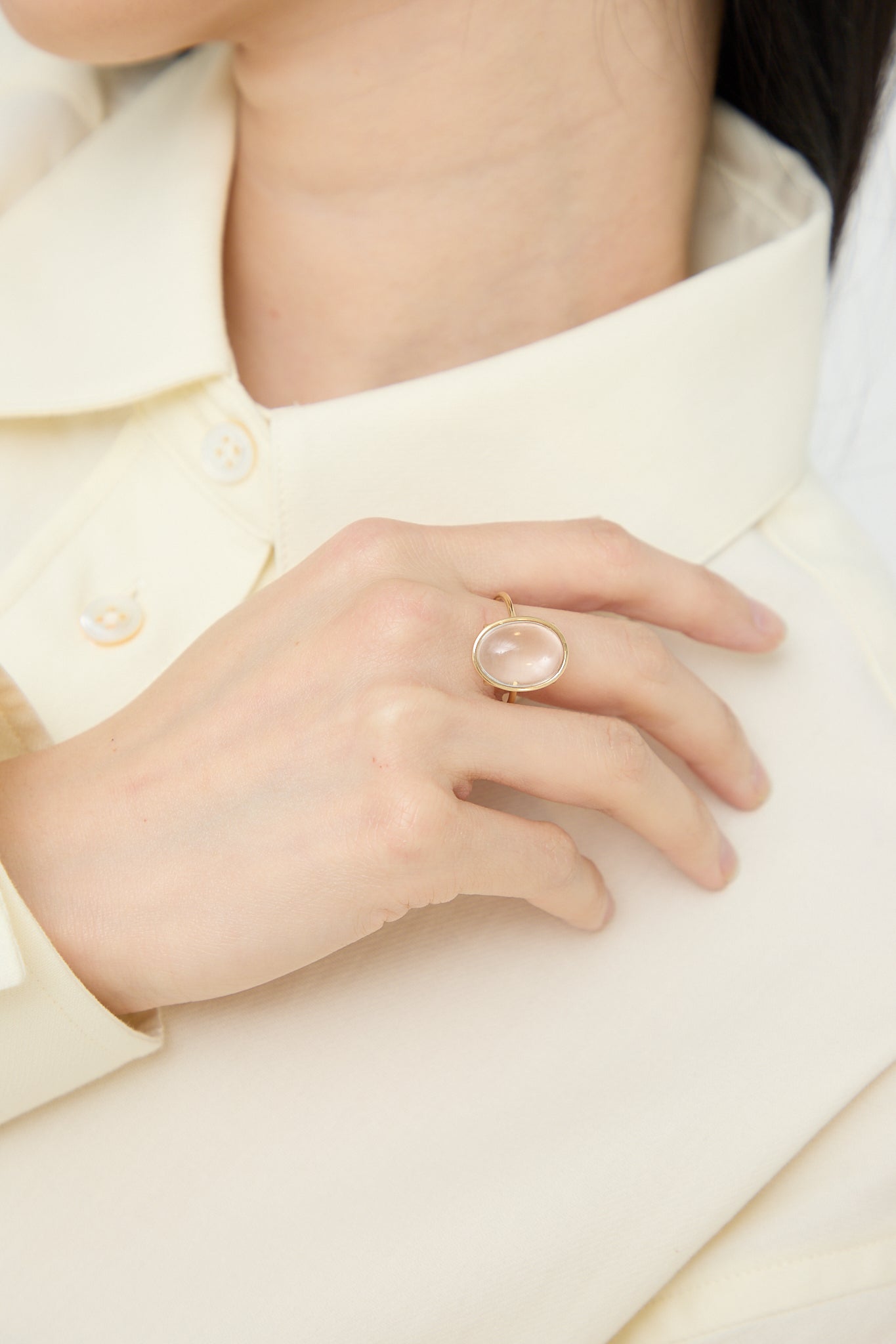 A woman wearing a white shirt and a Mary MacGill 14K Floating Ring in Crystal Quartz.
