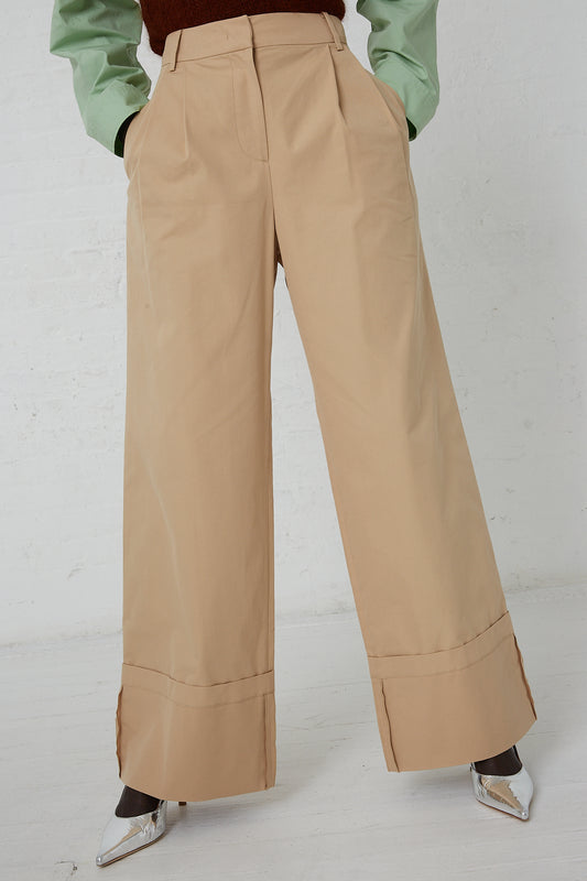 The model is wearing a green sweater and Rejina Pyo's Cotton Blend Macie Trouser in Tan. Front view and up close view of pant.