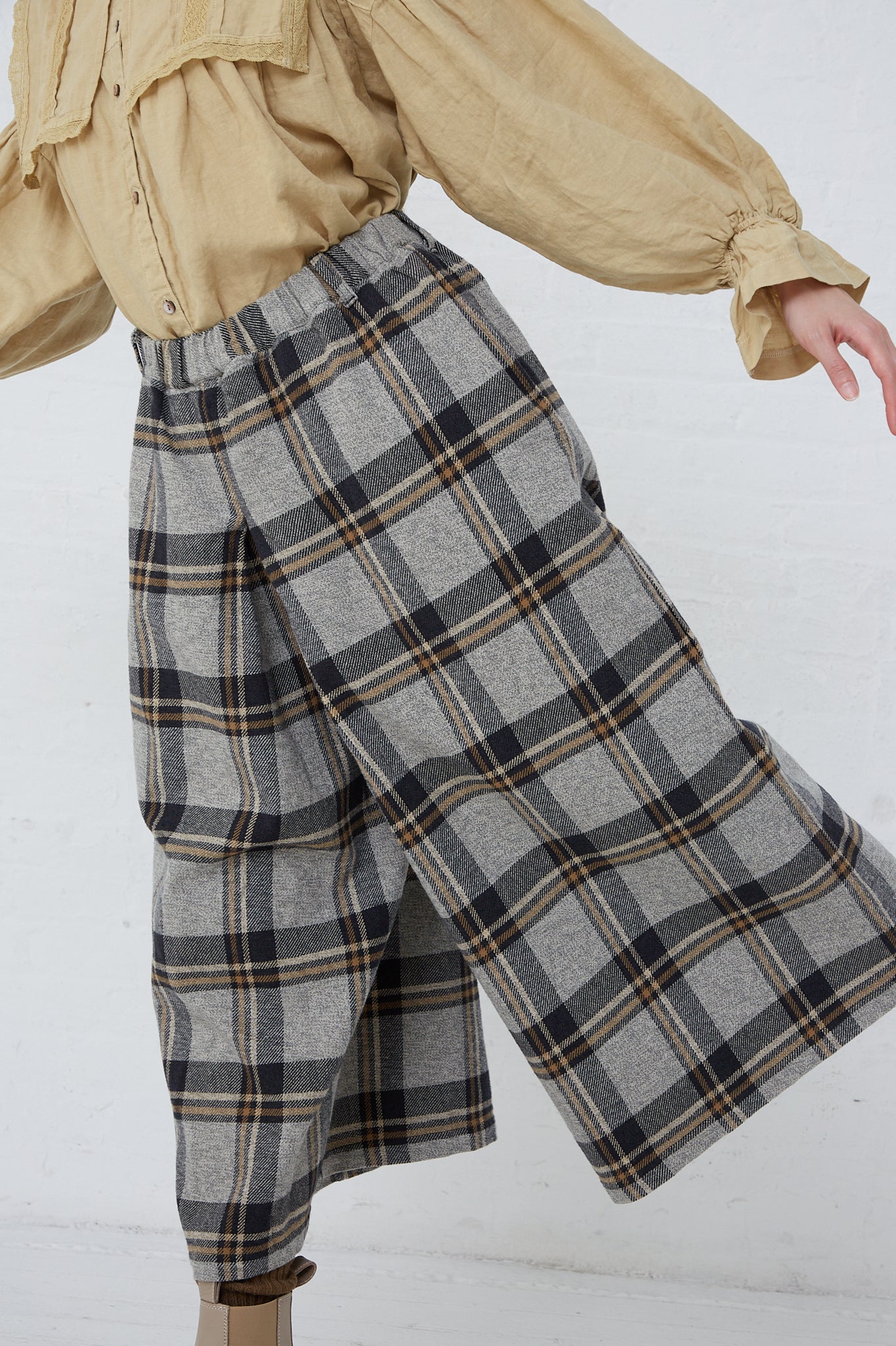 A woman wearing a "Cotton Heavy Twill Plaid Wide Leg Pant in Navy" made by nest Robe and paired with tan boots.