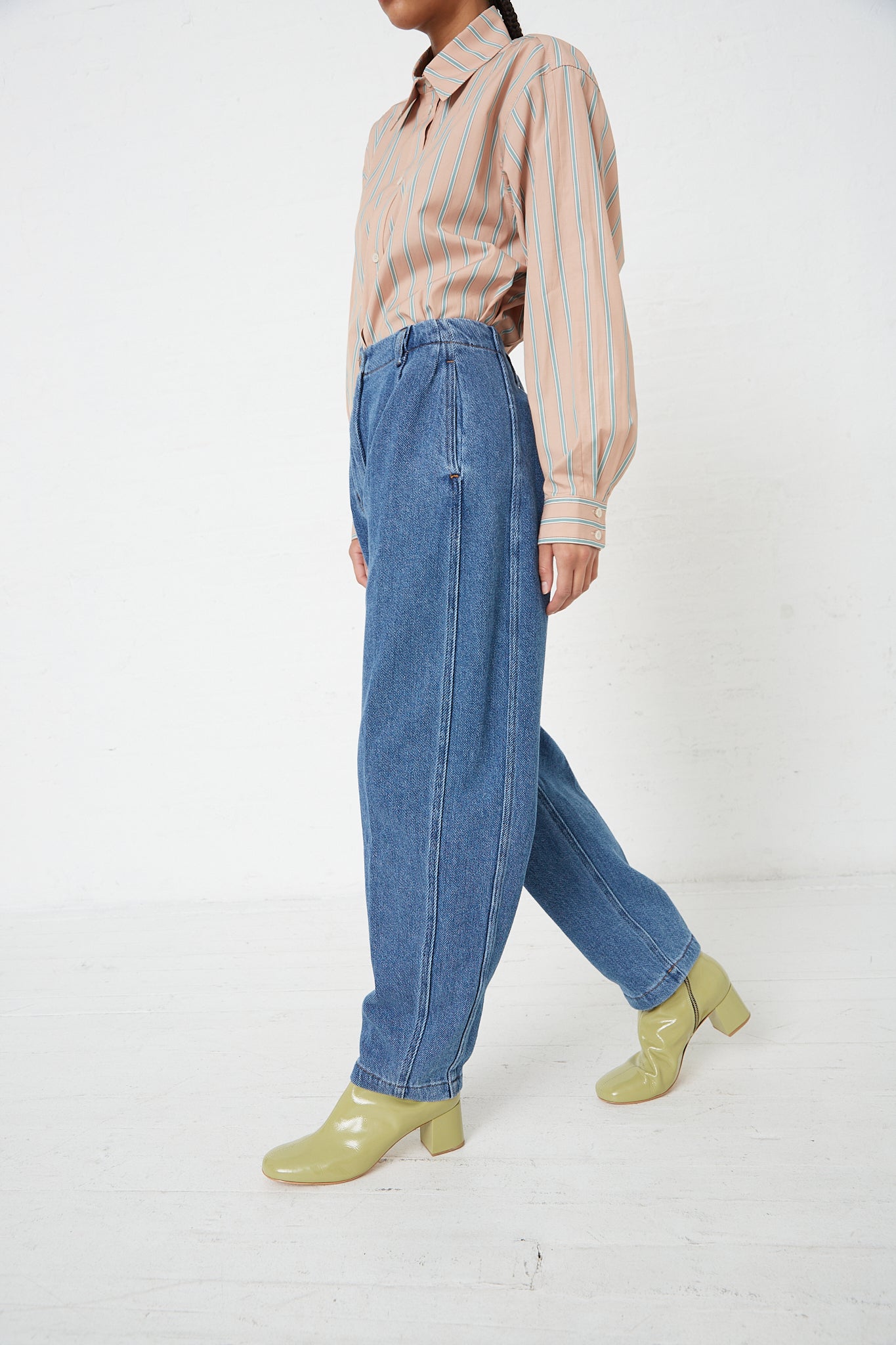 A woman in Rachel Comey's Denim Percy Pant in Indigo with a cocoon silhouette and a striped shirt.