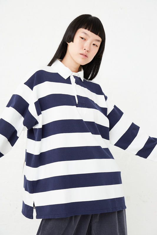 A model wearing a Toujours Cotton Jersey Rugby Shirt in Off White/Blue Stripe.