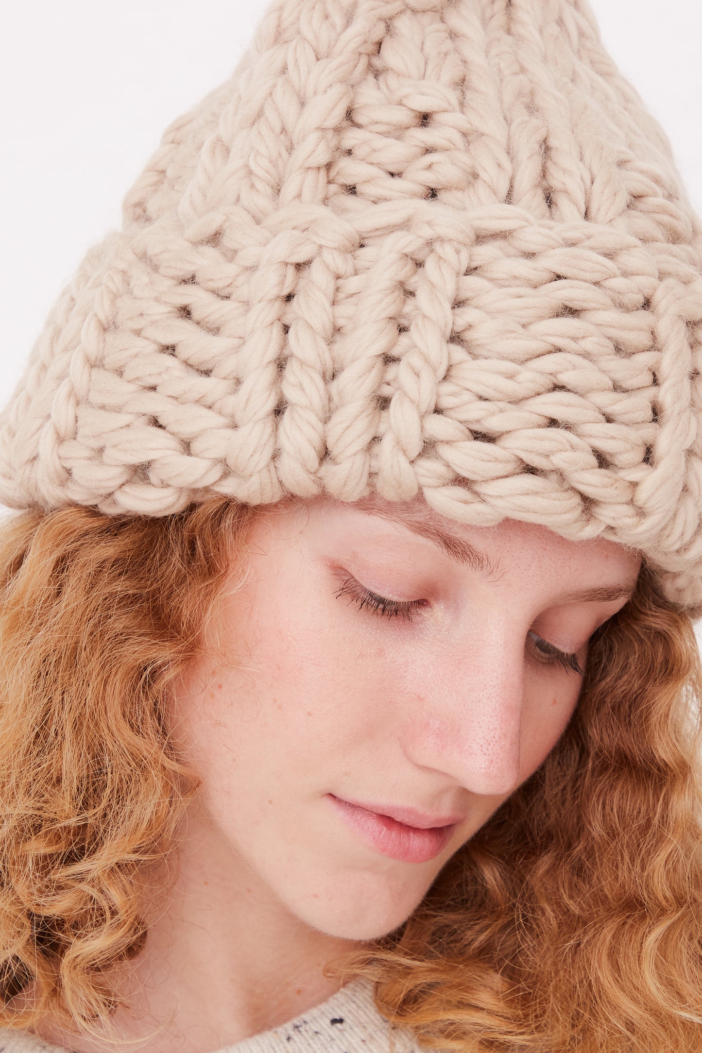 A woman wearing a Lauren Manoogian Handknit Chunky Rib Hat in Antique.