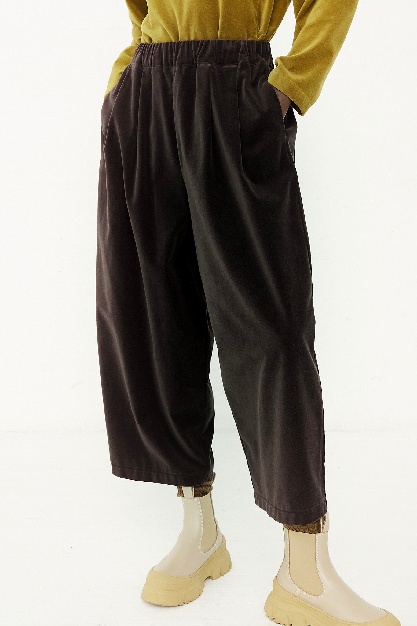 A woman wearing a yellow shirt and Black Crane cotton velveteen wide leg pants in Sumi Black.