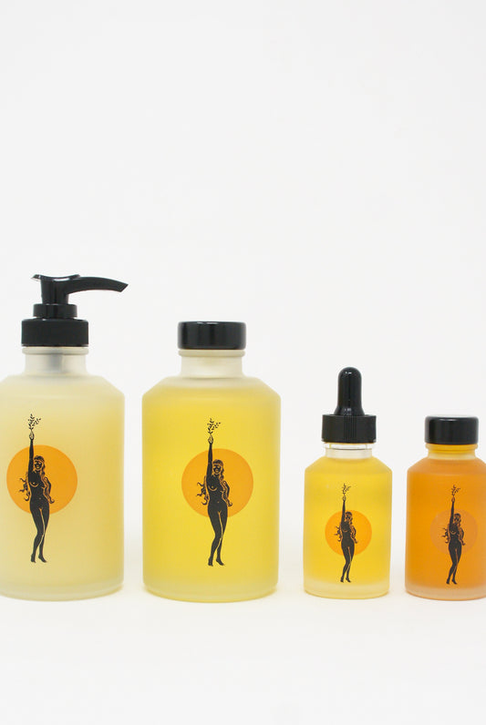 A set of Wonder Valley Hinoki Body Oil bottles with a woman's face on them.