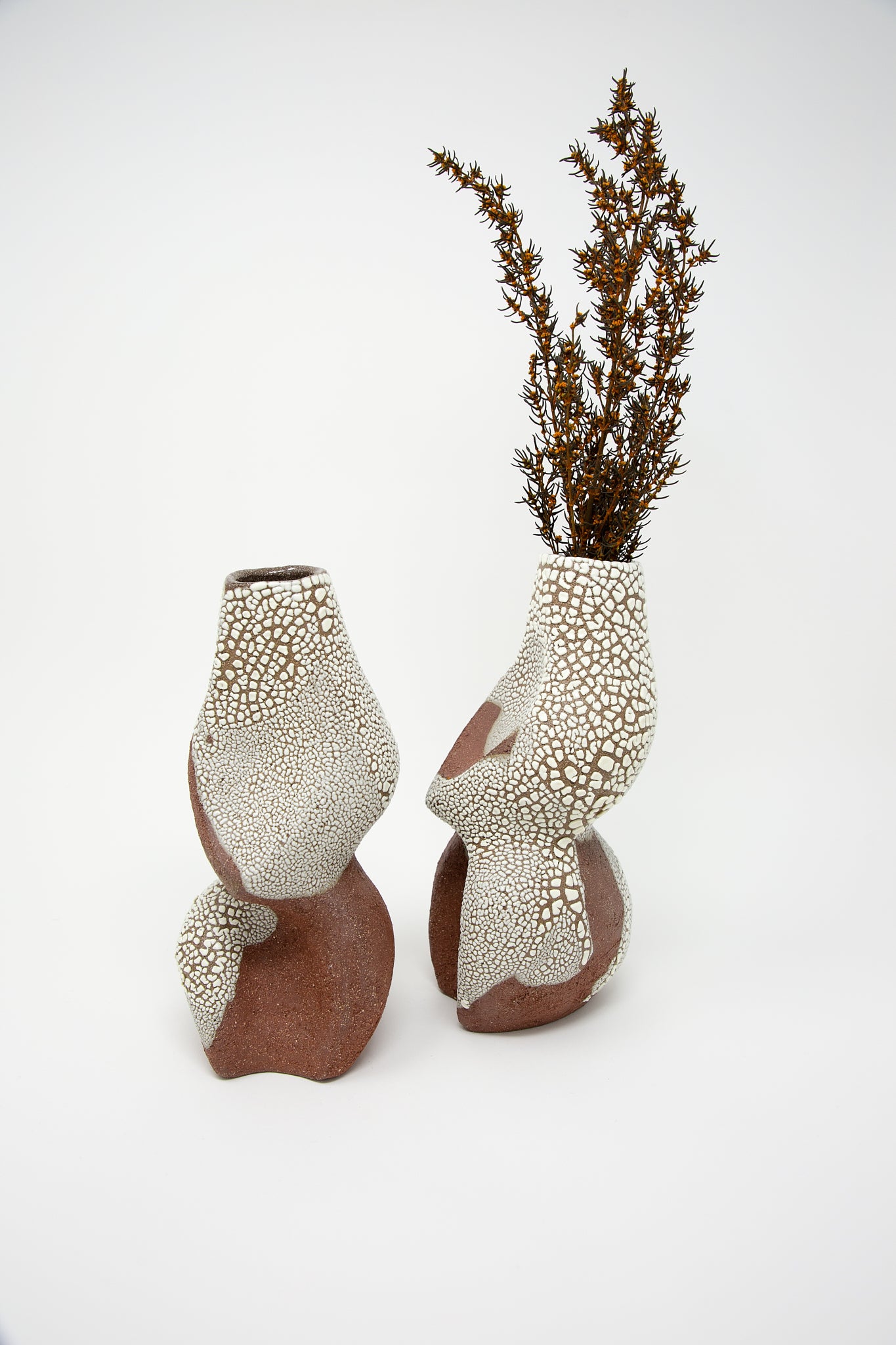A pair of Lost Quarry Hand Built Vessel No. 000743 Bud Vases with brown and white speckled designs.