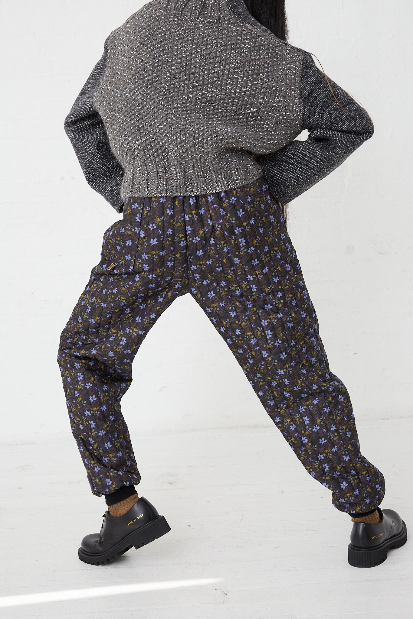 A woman wearing Monpe Pant No. 08 in Floral Print A - S by Bless, with an elasticated waist in a floral pattern.