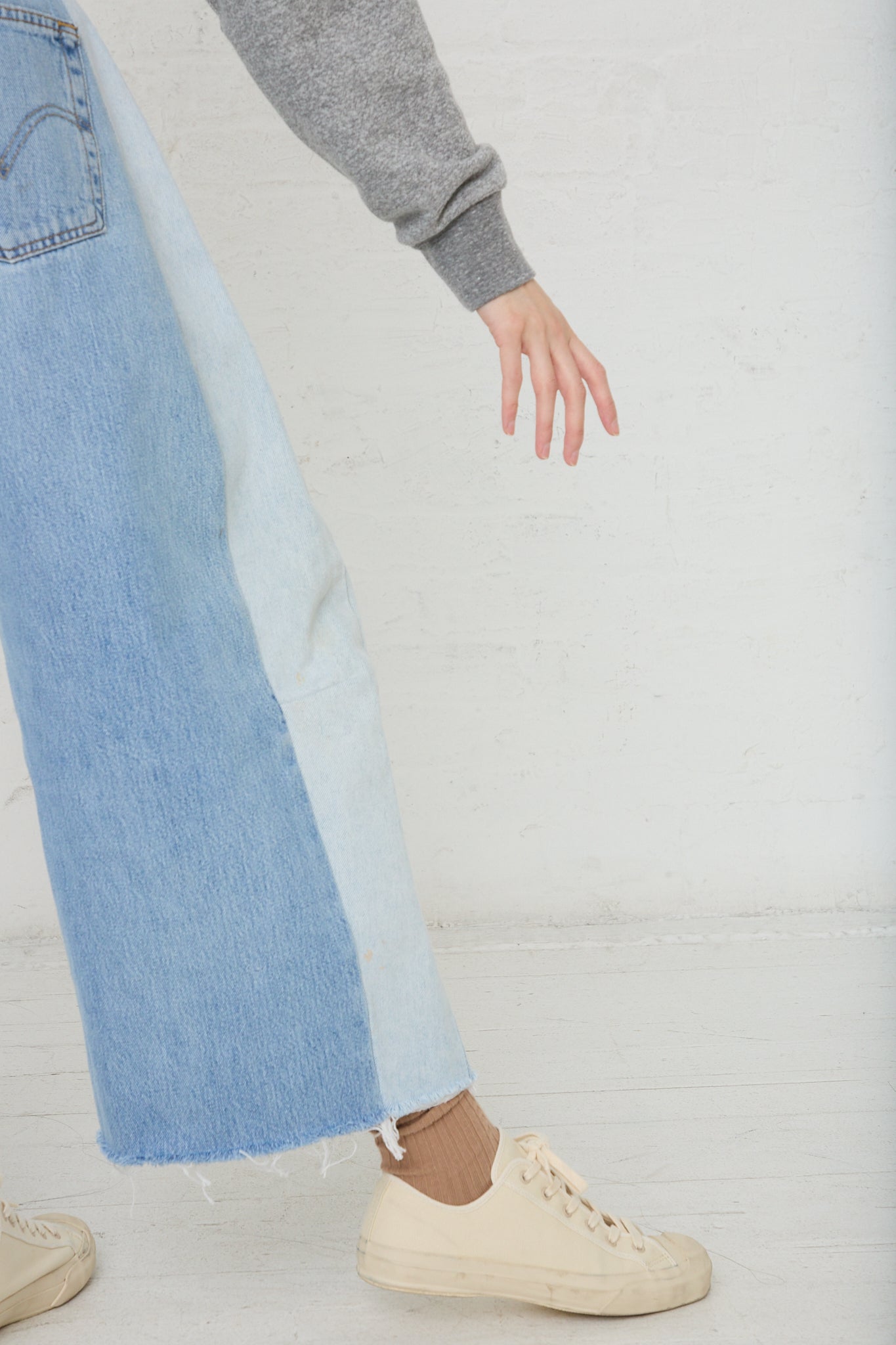 A woman wearing a pair of B Sides Lasso Jean in Vintage Indigo denim jeans and a cozy sweater.