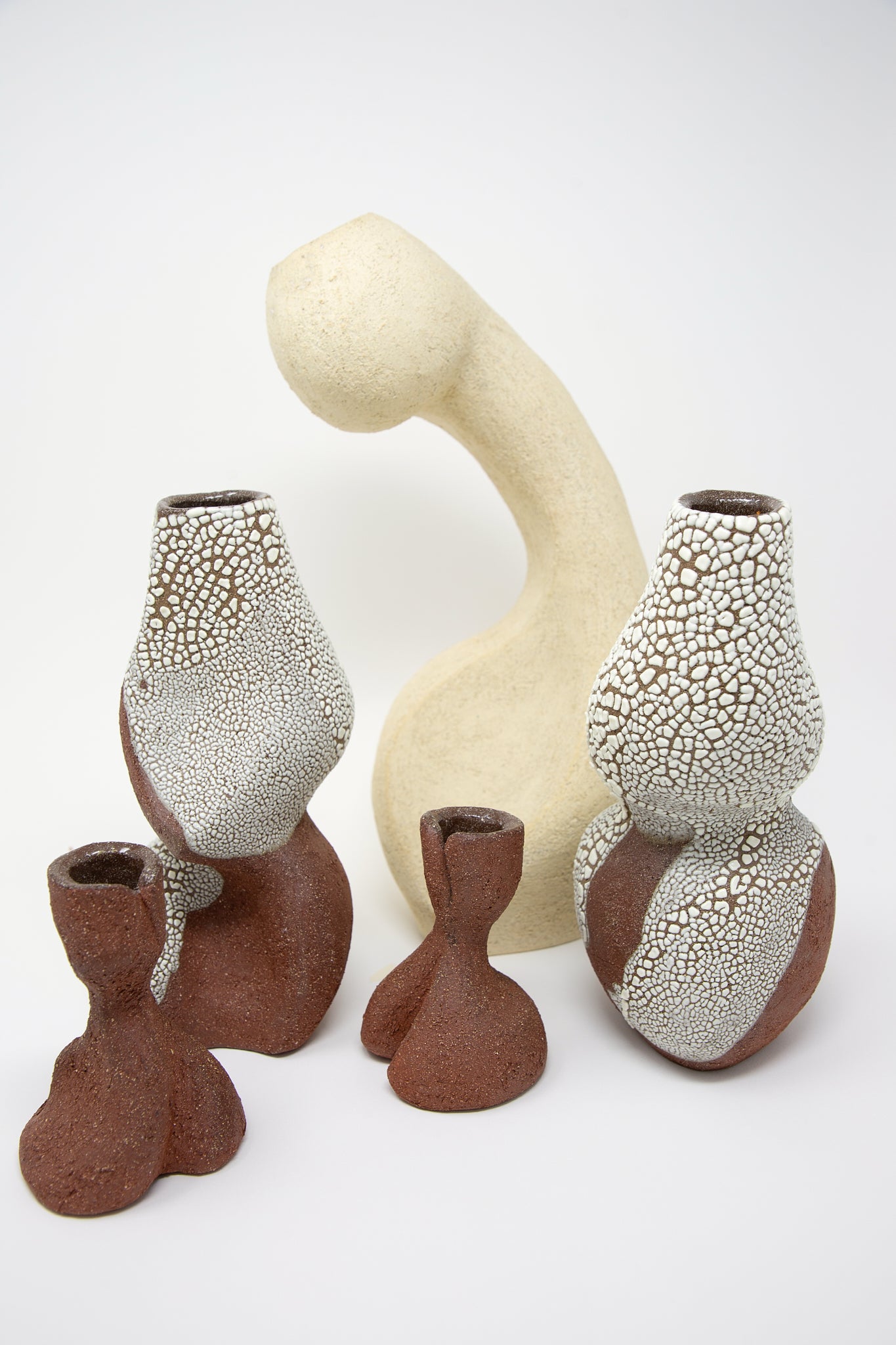 A collection of Lost Quarry's Hand Built Vessel No. 000743 Bud Vases, crackle-glazed terracotta ceramic vessels, displayed on a white surface.