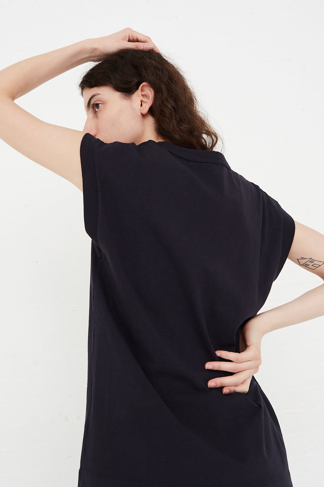 The back view of a model wearing a navy B Sides Cotton Pocket Tank in Overdyed Marine t-shirt.