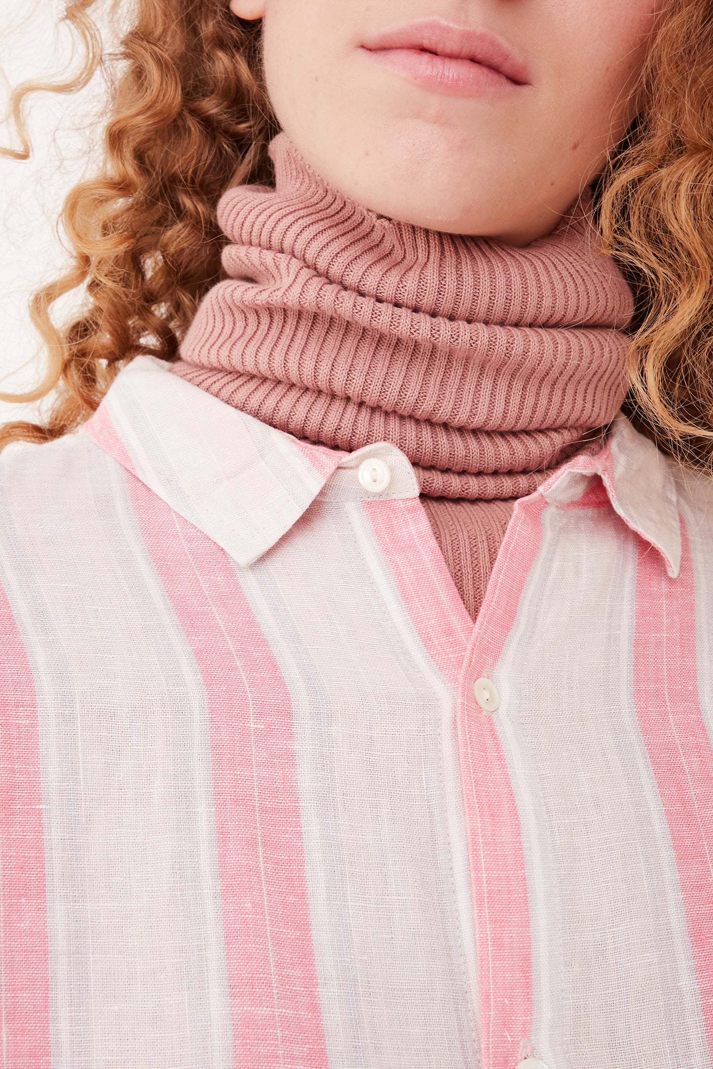 A woman wearing a relaxed fit Ichi Antiquités Linen Stripe Dress in Pink with a pink turtleneck.