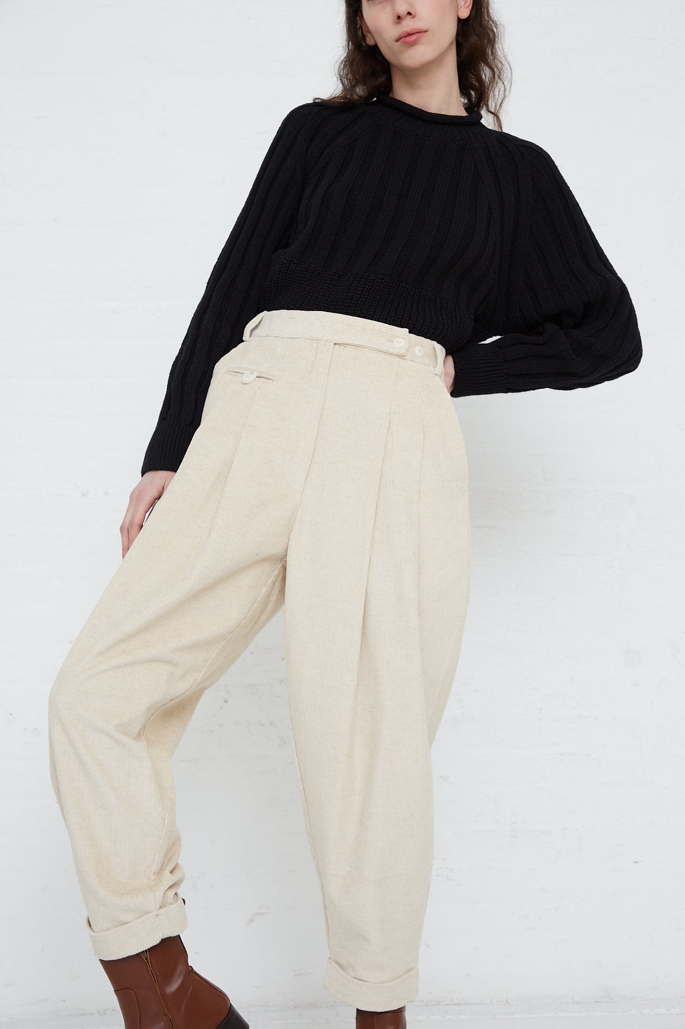The model is wearing a black Cordera sweater and Corduroy Carrot Pants in Off White made in Spain.