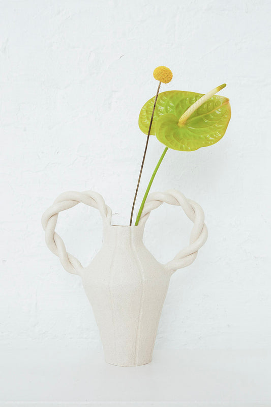 An Amphora Le Grand Tresse vase with a leaf in it, handmade in Spain by Clandestine.