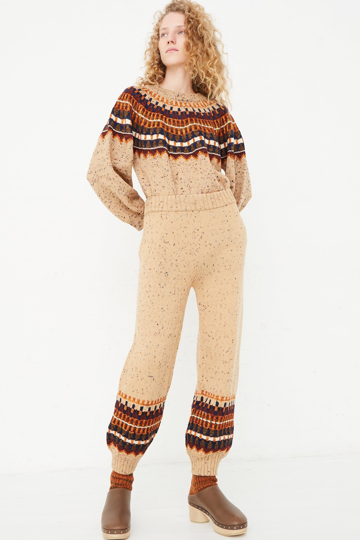 The model is wearing a beige Fair Isle Warm-Up Pant in Seed Confetti by Misha & Puff.