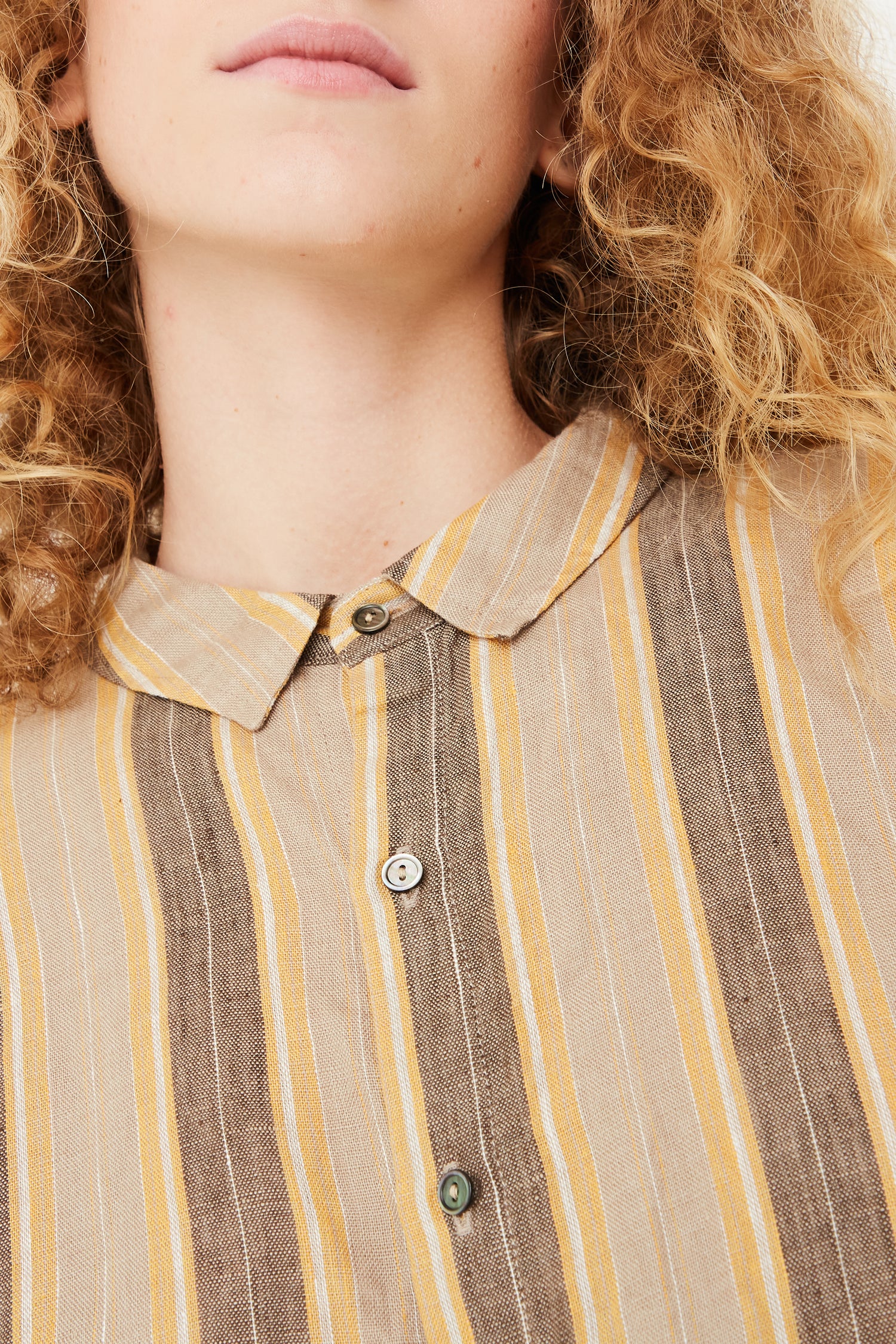 An up close detail view of a model wearing an Ichi Antiquités Linen Stripe Shirt in Mustard.