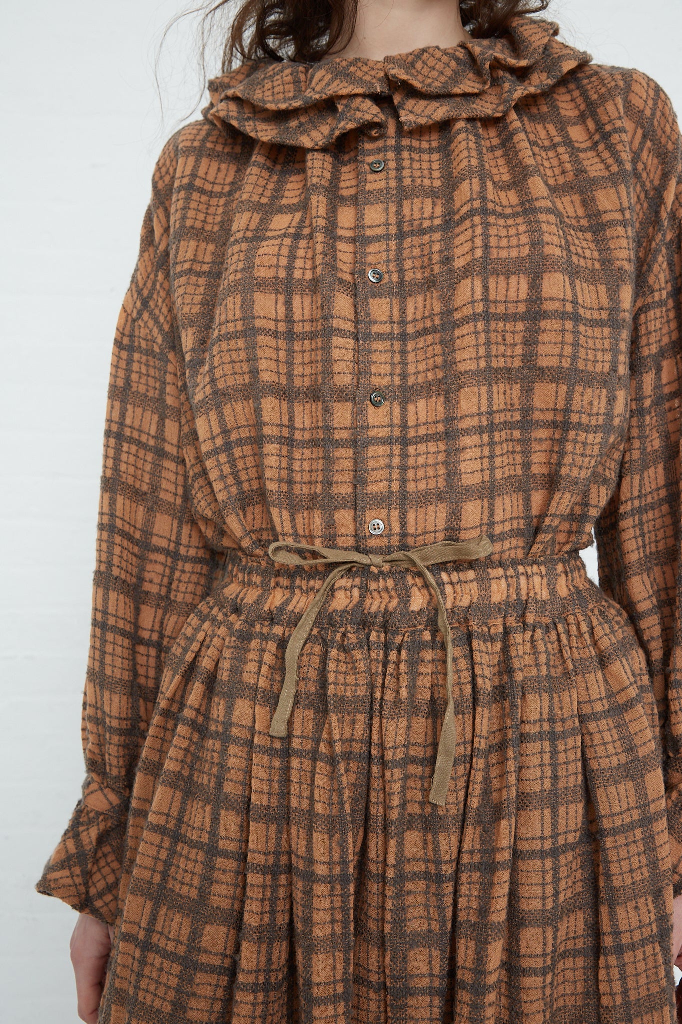 A woman wearing a Woven Wool Check Skirt in Terracotta by Ichi Antiquités.