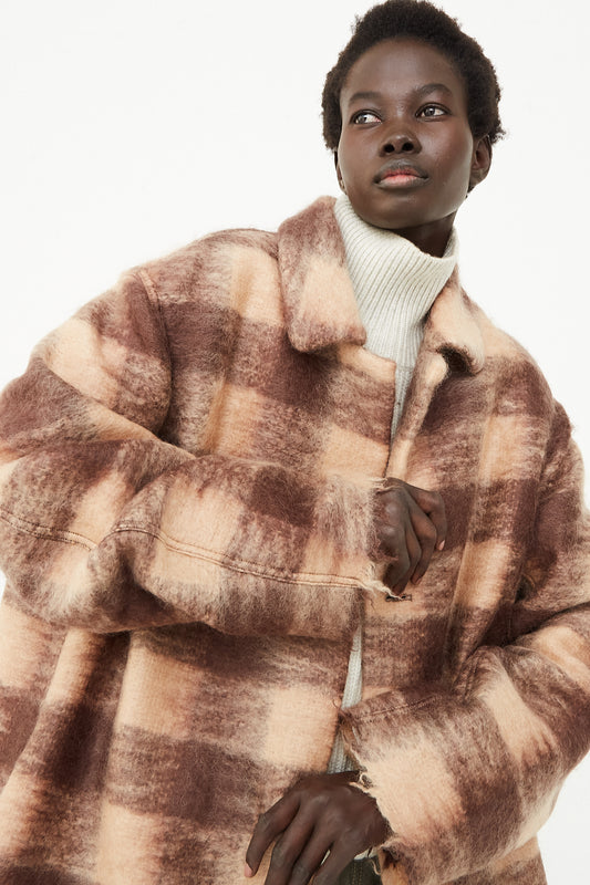 A model wearing an oversized coat in a check mohair blend. Features a fold-over collar, dropped shoulders and front button closure. Up close and front view. Designed by Sofie D'Hoore - Oroboro Store